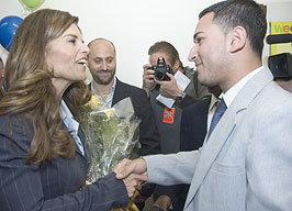 Ulises Benavides, Vice President, LATTC Associated Student Organization greets Maria Shriver and presents her with a bouquet of yellow roses.